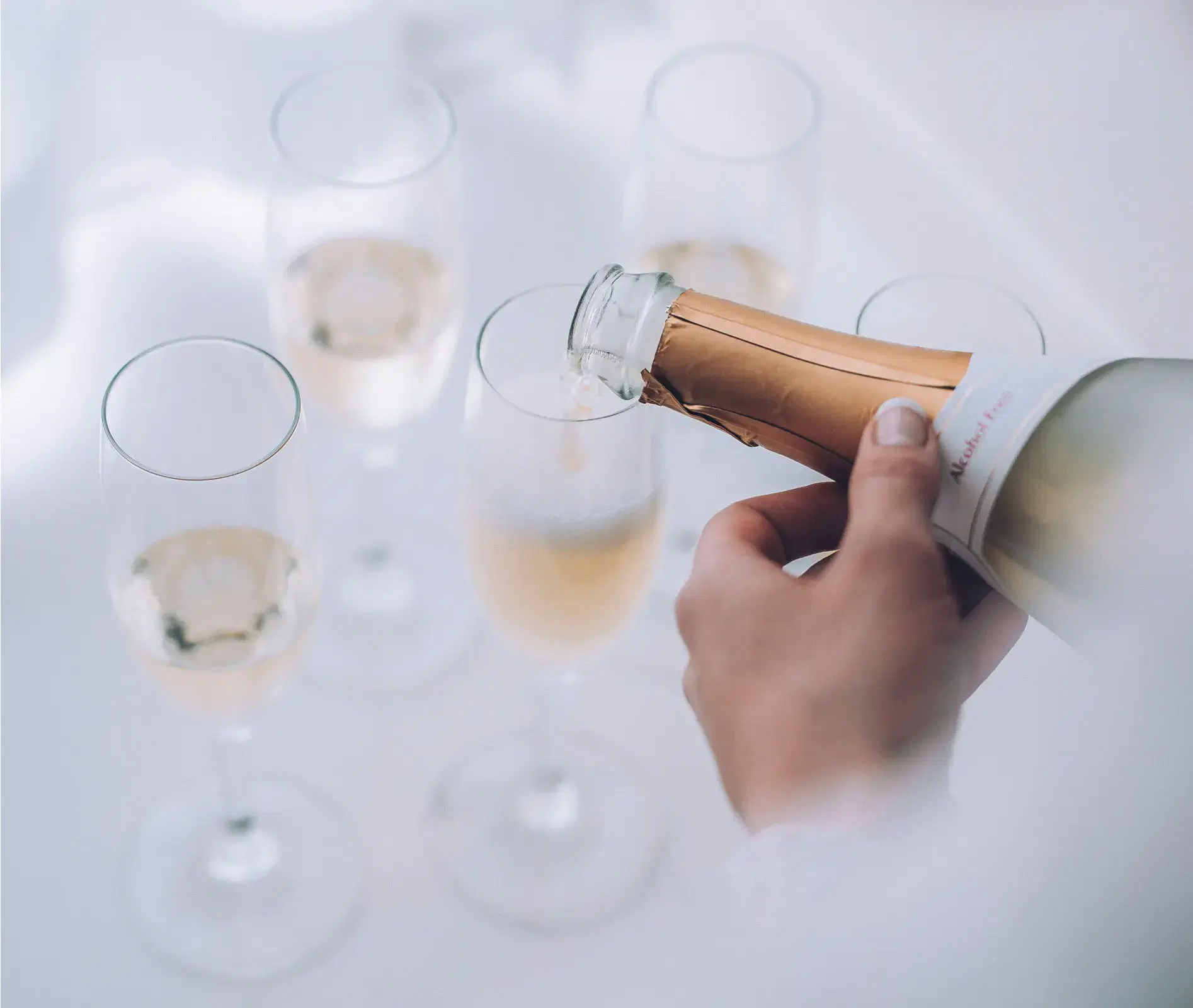 Champagne being poured into flutes for a welcome arrival amenity